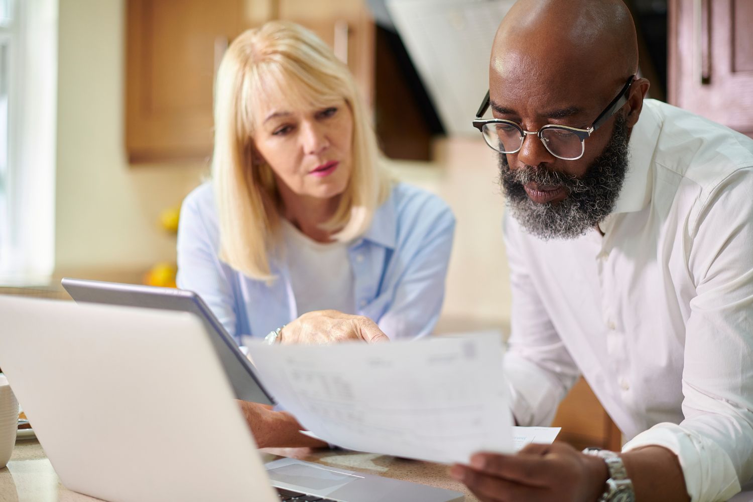 Couple looking at documents and laptop